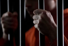 Person holding metal bars in dark setting