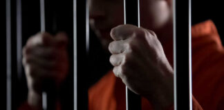 Person holding metal bars in dark setting