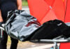 Person carrying body bag on stretcher outdoors