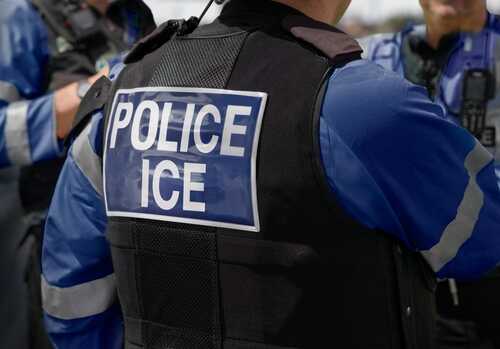 shutterstock_2615419741 (10).jpg Close-up of a police officer's uniform with 'POLICE ICE' on the back