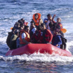 A group of people in a red inflatable boat on the ocean