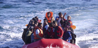 A group of people in a red inflatable boat on the ocean
