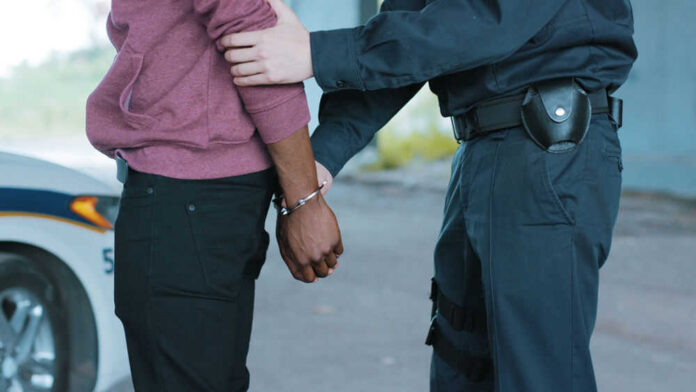 Police officer arresting a person outdoors