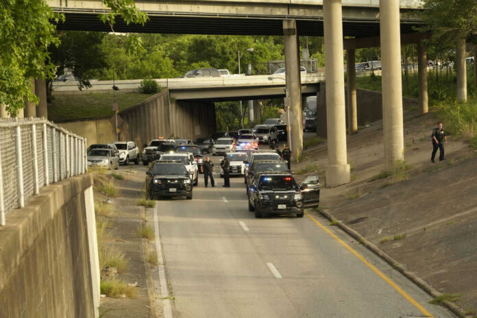 Police cars blocking road underneath highway overpass