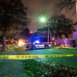 Police car at night with caution tape nearby
