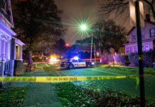 Police car at night with caution tape nearby