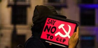Protester holding a sign that says 'Say No to CCP' with a hammer and sickle symbol
