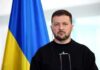 A political leader standing in front of a Ukrainian flag during a press conference