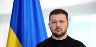 A political leader standing in front of a Ukrainian flag during a press conference
