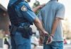 Police officer handcuffing a suspect in a street setting
