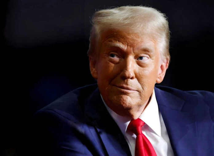 Person wearing suit and red tie looking sideways