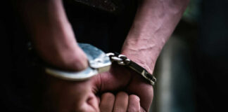 Hands in handcuffs behind the back tightly secured