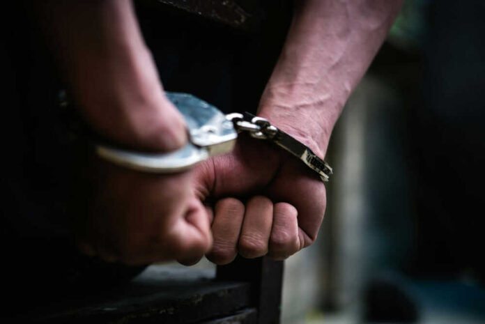 Hands in handcuffs behind the back tightly secured