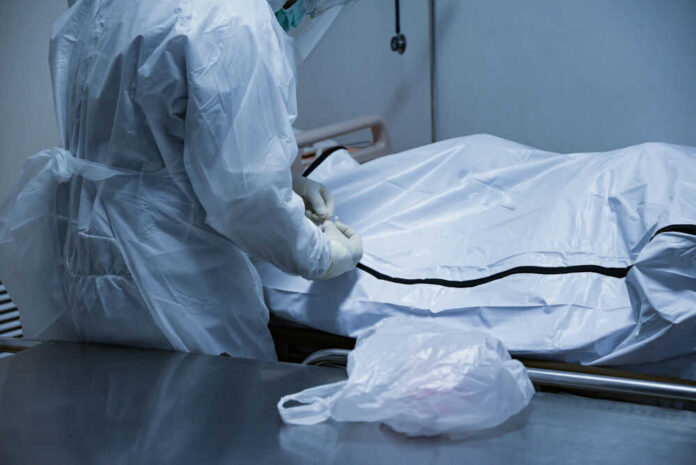 1713746299 Person in protective gear handling body bag