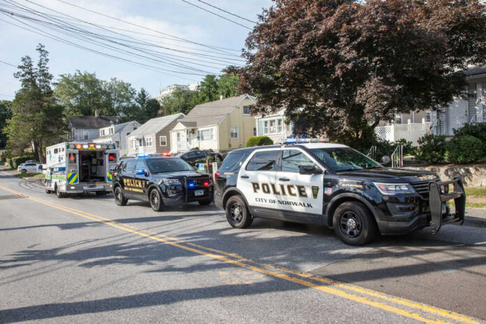 1803936988 Police and ambulance vehicles parked on street