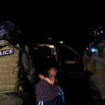 Police officers arresting a person at night
