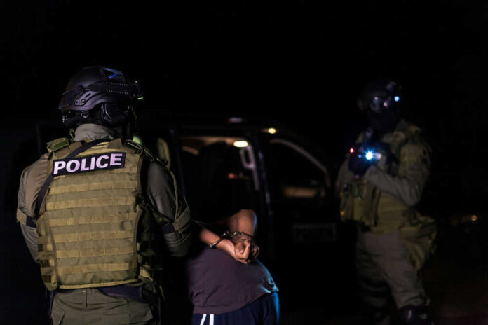 Police officers arresting a person at night