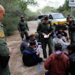 Border patrol agents detaining a group of people