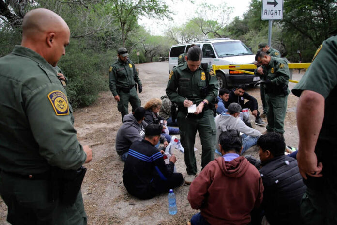 Border patrol agents detaining a group of people