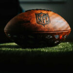 NFL football resting on artificial grass indoors