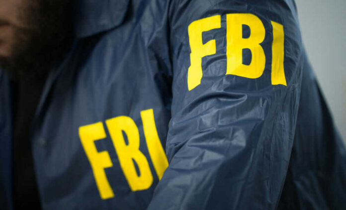 Person wearing blue jacket with FBI lettering