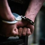 Hands in handcuffs behind the back tightly secured