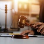 A lawyer striking a gavel on a desk in a courtroom setting
