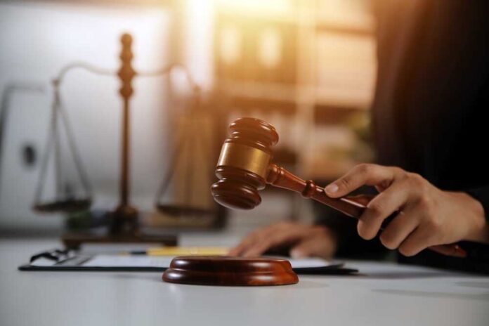 A lawyer striking a gavel on a desk in a courtroom setting