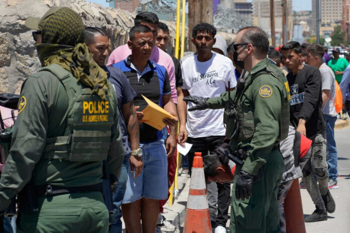 Border officers interacting with a group of people