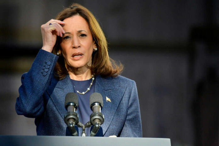 Woman speaking at a podium outdoors in blue suit