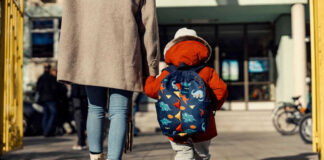Adult and child walking towards a school building