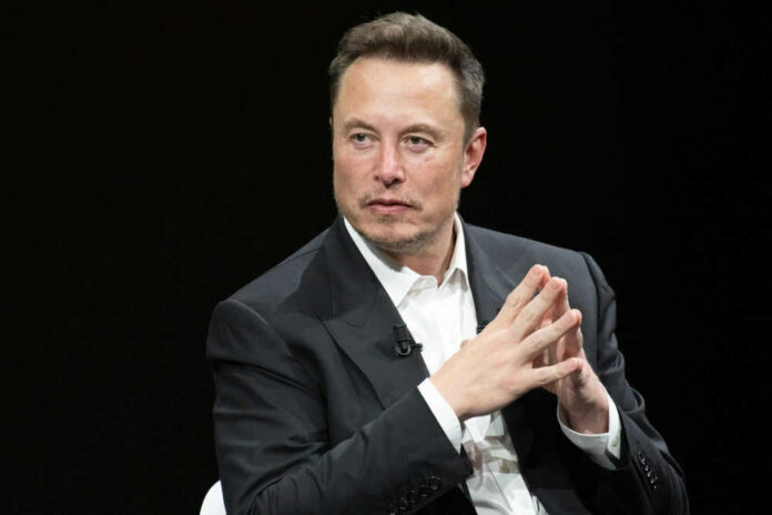 Man in black suit sitting with hands clasped