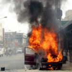 Car engulfed in flames on busy urban street