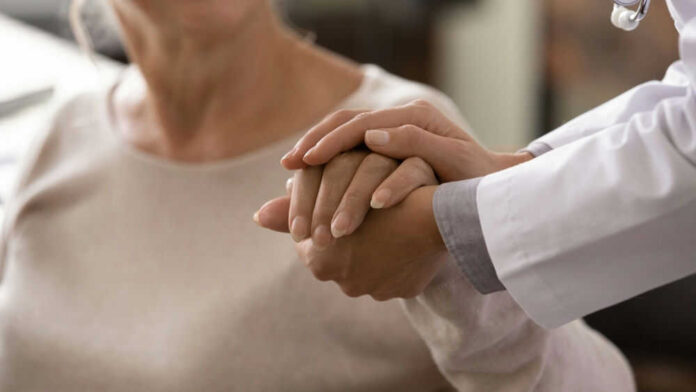 Doctor holding patients hand in comforting gesture